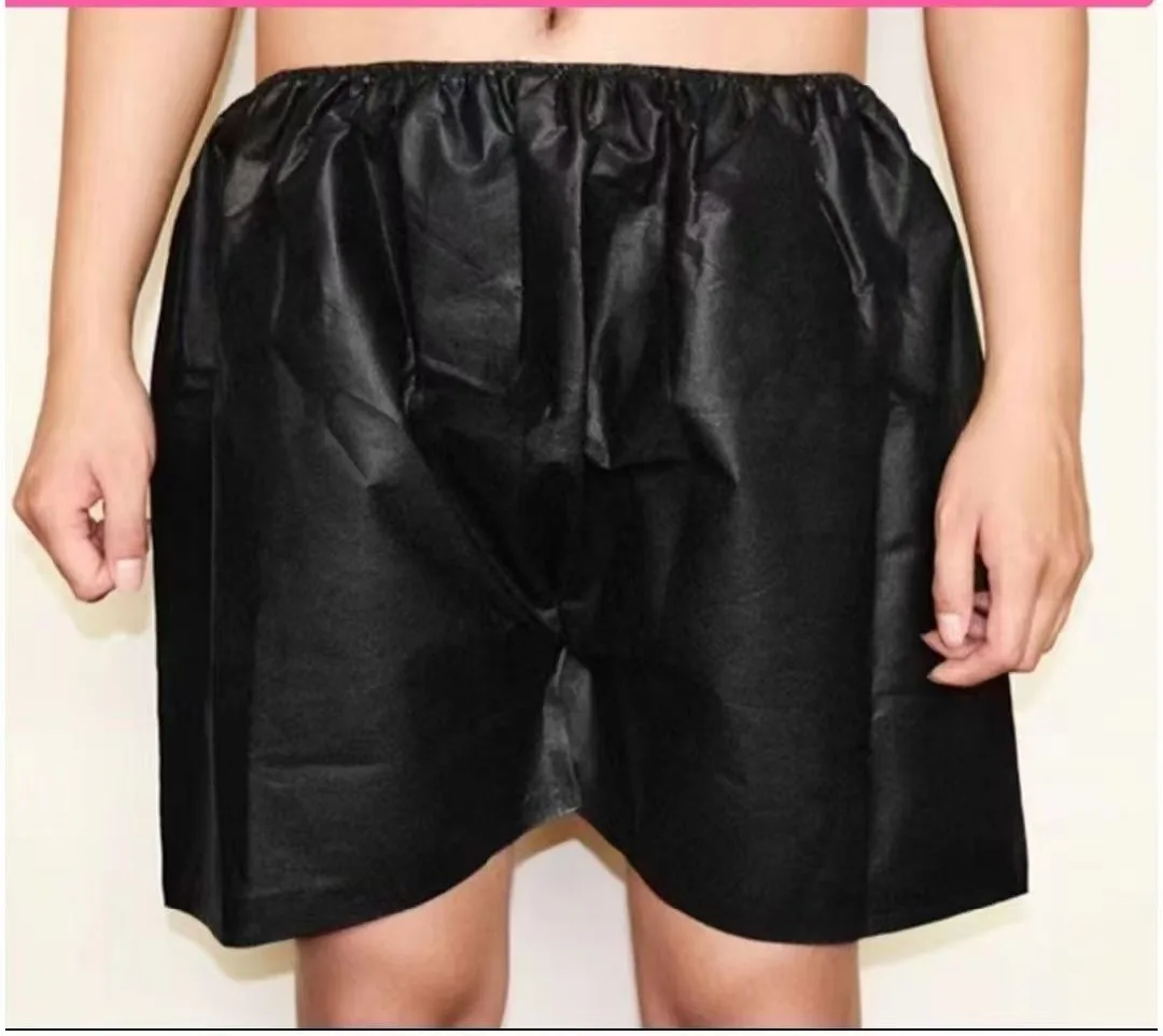 Black disposable non-woven boxer shorts worn by model for spa and beauty salon wholesale