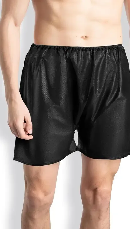 Black disposable non-woven boxer shorts on model, individually wrapped for salon wholesale